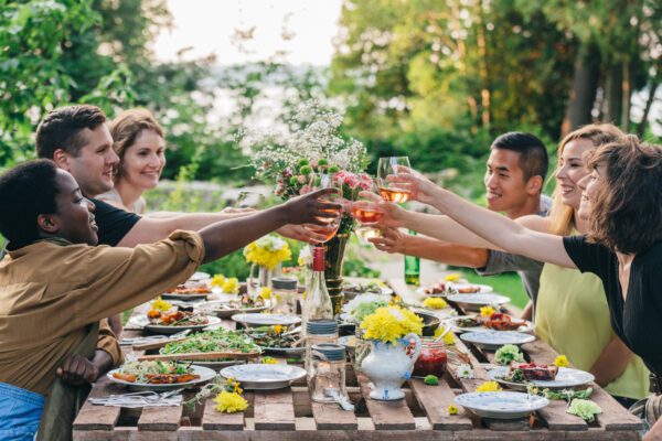 A group of friends saying a toast at an outdoor dinner party