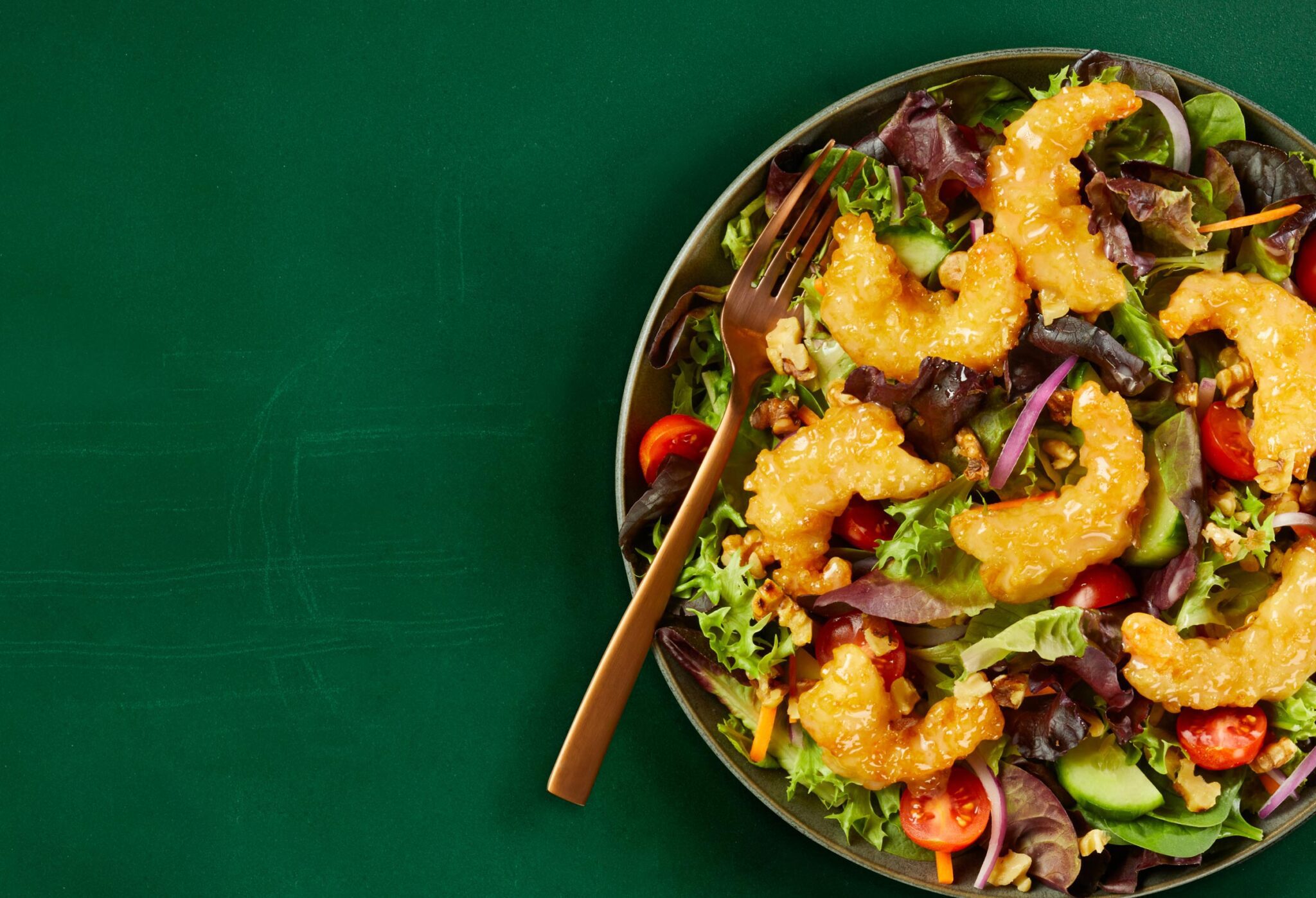 bowl of salad with shrimp on top and a fork in it