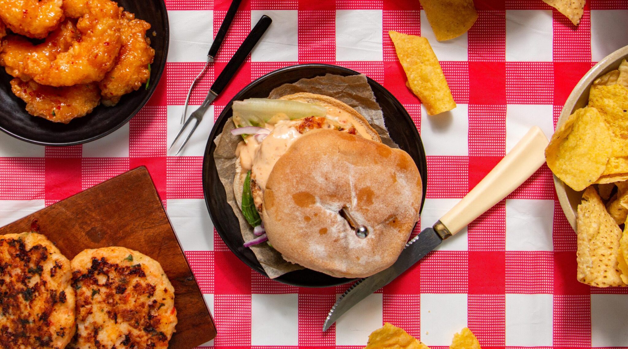 Table set with shrimp, shrimp burgers and chips