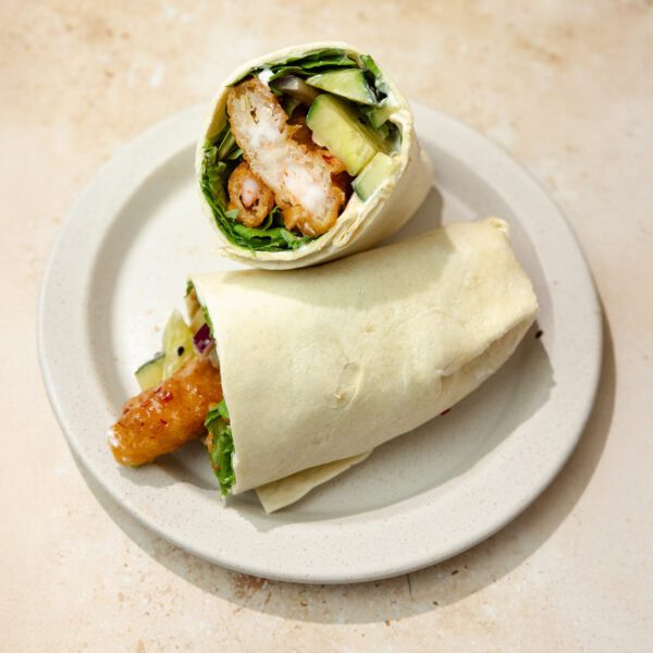 Three-quarter view of Sweet & Spicy Shrimp Wraps cut in half with one propped up against another.