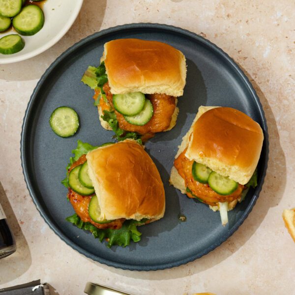 Overhead view of three Social Kitchens Sweet & Spicy Shrimp Sliders on a grey plate.