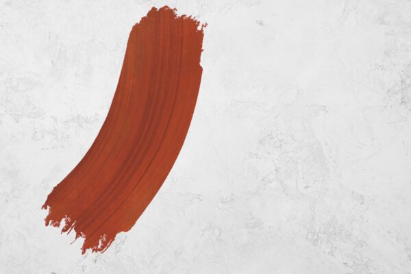 Orange-red paint swash on a white stone texture background.